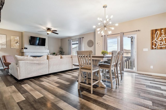 dining area featuring ceiling fan with notable chandelier and hardwood / wood-style flooring