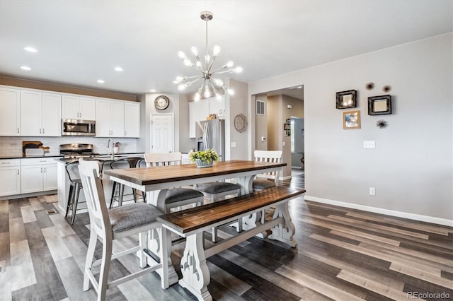 dining space with a chandelier, dark hardwood / wood-style flooring, and sink