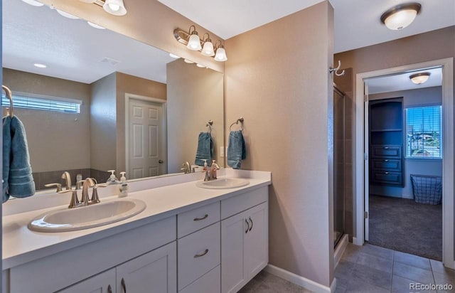 bathroom featuring tile patterned flooring, a shower with door, and vanity