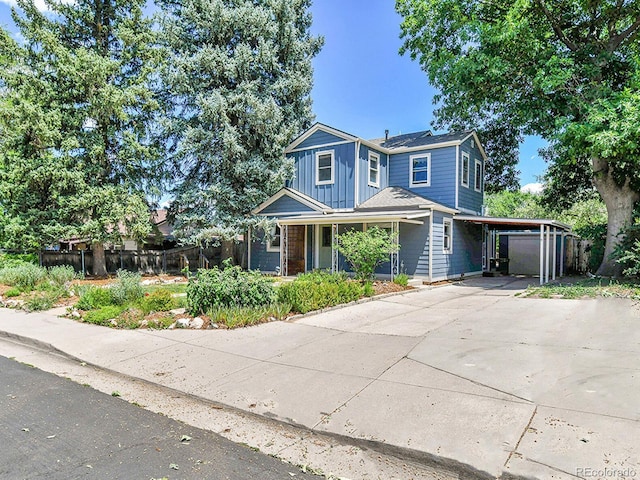 3282 Depew St, Wheat Ridge, CO 80212 - view of front of house featuring concrete driveway, a carport, a porch, and board and batten siding