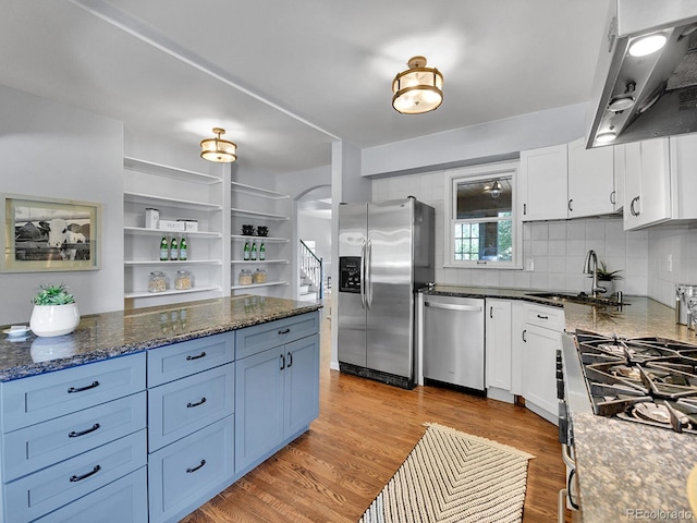 3282 Depew St, Wheat Ridge, CO 80212 - kitchen with stainless steel appliances, range hood, white cabinetry, and open shelves