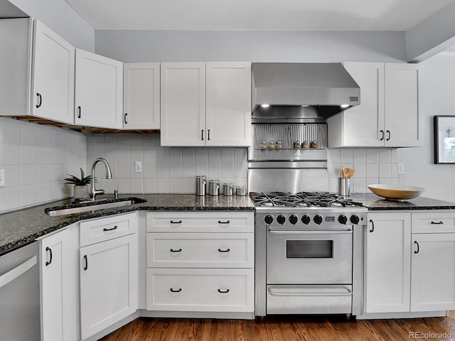 3282 Depew St, Wheat Ridge, CO 80212 - kitchen with stainless steel appliances, wall chimney exhaust hood, tasteful backsplash, and white cabinets