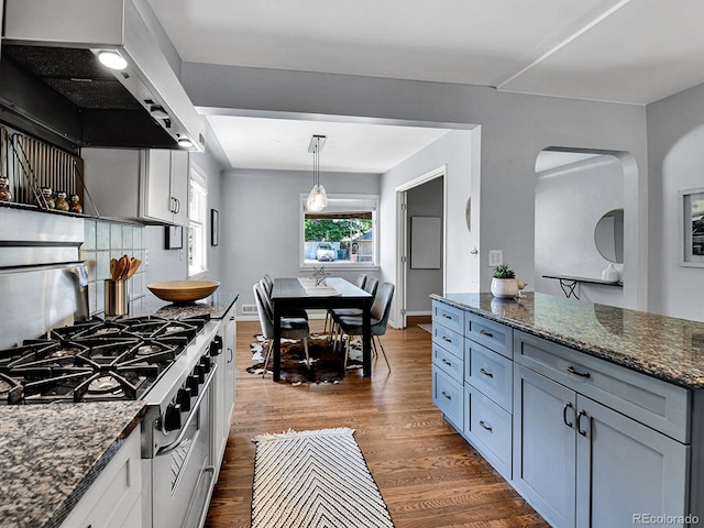 3282 Depew St, Wheat Ridge, CO 80212 - kitchen featuring exhaust hood, arched walkways, dark wood-style floors, and stovetop