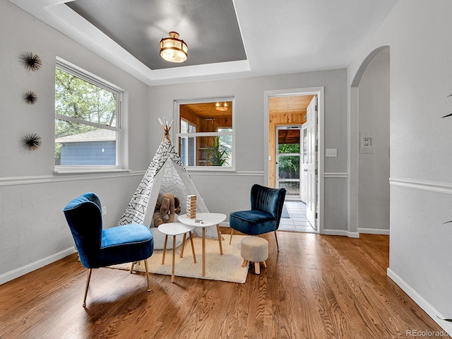 3282 Depew St, Wheat Ridge, CO 80212 - living area featuring arched walkways, wood finished floors, plenty of natural light, and a raised ceiling