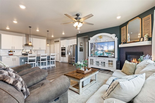 599 Fall River Ct, Brighton, CO 80601 - living room with a ceiling fan, recessed lighting, wood finished floors, and a fireplace