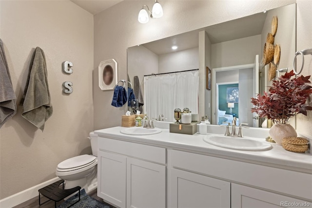 599 Fall River Ct, Brighton, CO 80601 - bathroom with double vanity, a shower with curtain, and wood finished floors