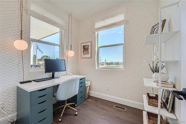 office space featuring dark wood-style flooring, visible vents, plenty of natural light, and baseboards