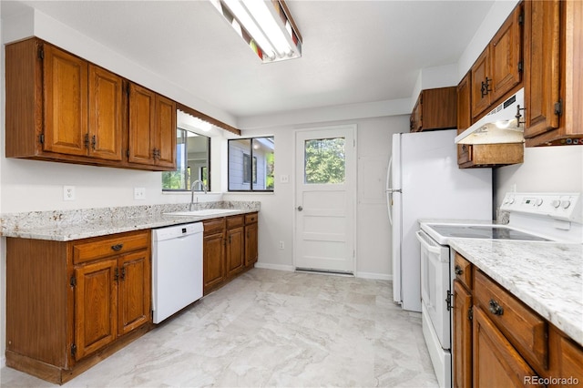 3955 S Hazel Ct, Englewood, CO 80110 - kitchen featuring white appliances, under cabinet range hood, brown cabinetry, light marble finish floors, and light stone counters