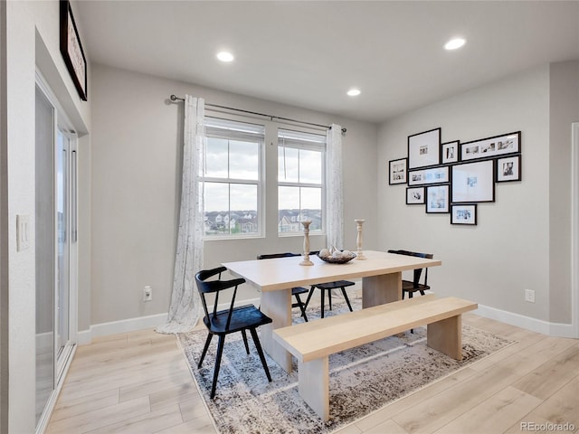 dining room with light wood finished floors, baseboards, and recessed lighting