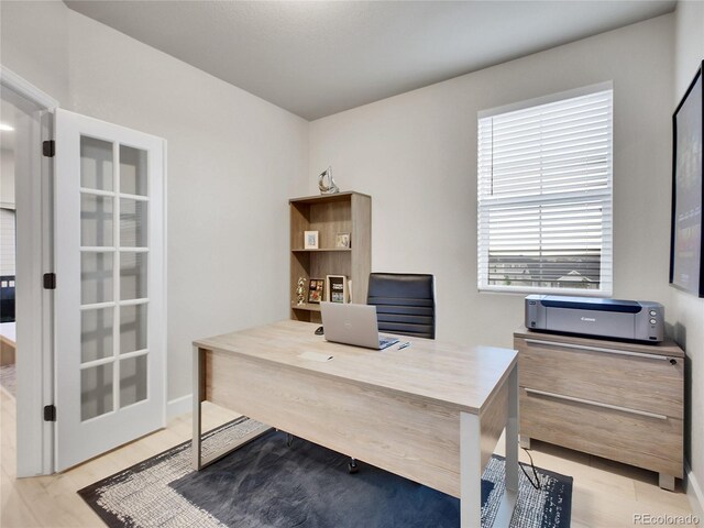 office area with light wood-style floors and baseboards