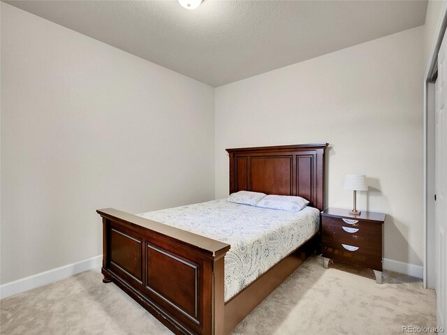 bedroom featuring light carpet and baseboards