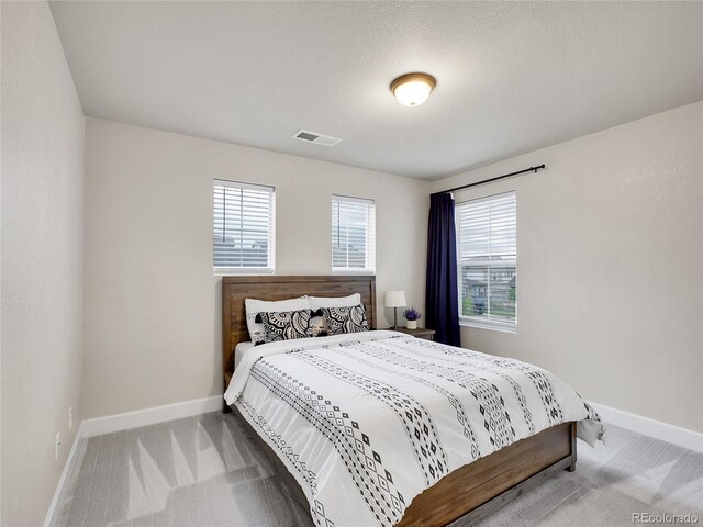 bedroom with carpet, baseboards, and multiple windows