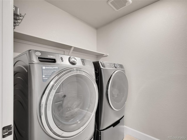 laundry room featuring washing machine and dryer and baseboards