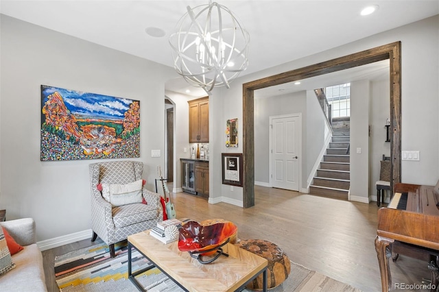 living room with wine cooler, a chandelier, and light hardwood / wood-style floors