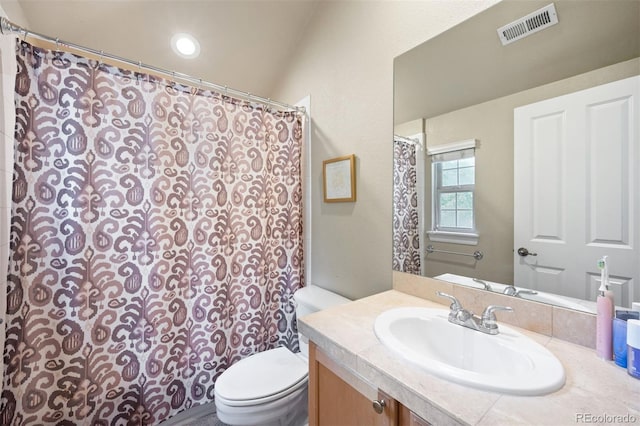 bathroom with vanity, lofted ceiling, and toilet