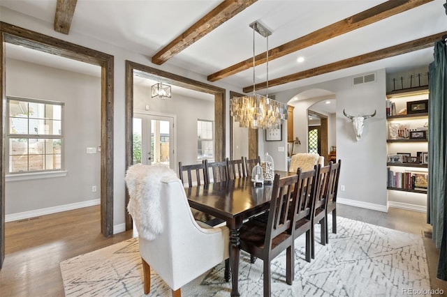 dining space featuring hardwood / wood-style floors and beam ceiling