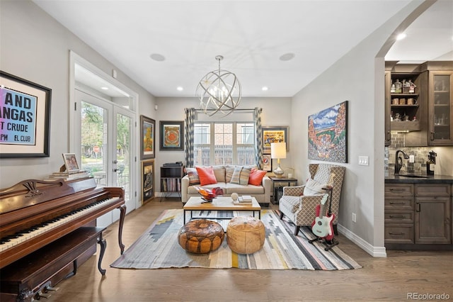 sitting room featuring a chandelier, sink, a healthy amount of sunlight, and light hardwood / wood-style flooring