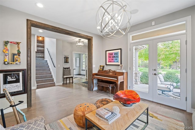 living room featuring a chandelier, french doors, and light hardwood / wood-style floors