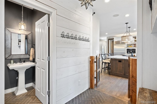 hall with dark hardwood / wood-style flooring and wood walls