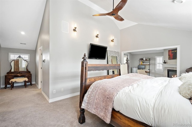 bedroom featuring ceiling fan, lofted ceiling, light carpet, and multiple windows