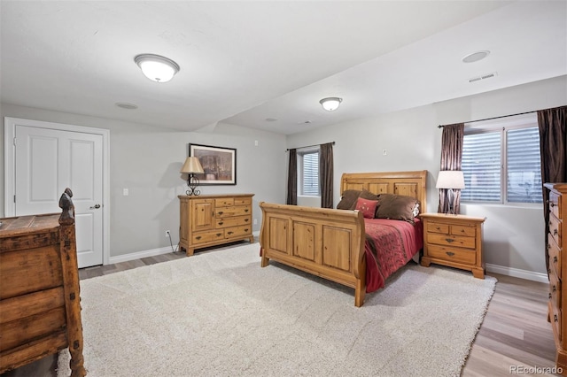 bedroom featuring multiple windows and light wood-type flooring