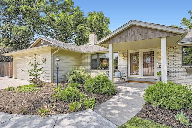 5475 W Ottawa Ave, Littleton, CO 80128 - ranch-style house featuring brick siding, a garage, a chimney, driveway, and covered porch