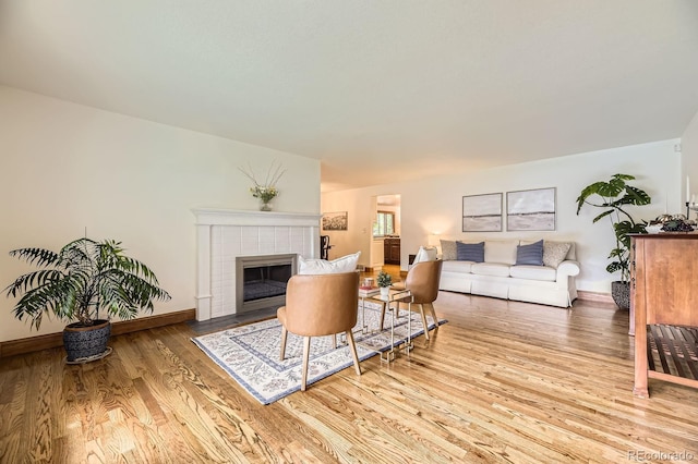 5475 W Ottawa Ave, Littleton, CO 80128 - living room featuring wood finished floors, a tile fireplace, and baseboards