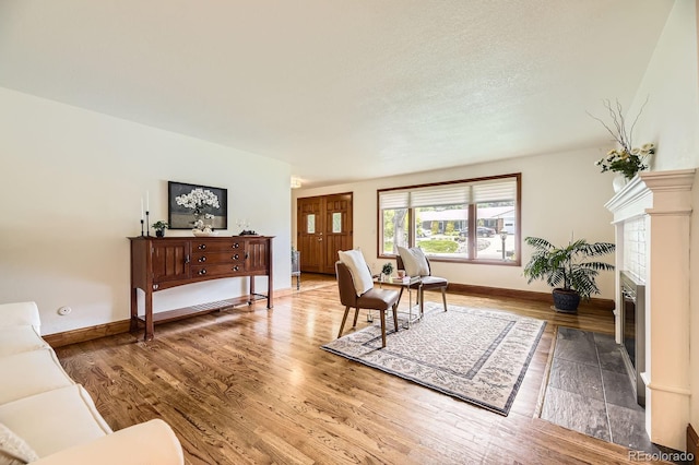 5475 W Ottawa Ave, Littleton, CO 80128 - living area with wood finished floors, baseboards, and a tiled fireplace