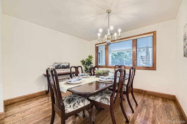 5475 W Ottawa Ave, Littleton, CO 80128 - dining area with a chandelier, baseboards, and light wood finished floors