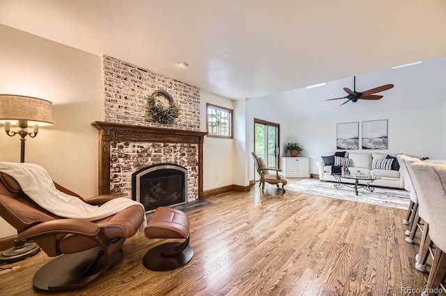 5475 W Ottawa Ave, Littleton, CO 80128 - living area with wood finished floors, a brick fireplace, a ceiling fan, lofted ceiling, and baseboards