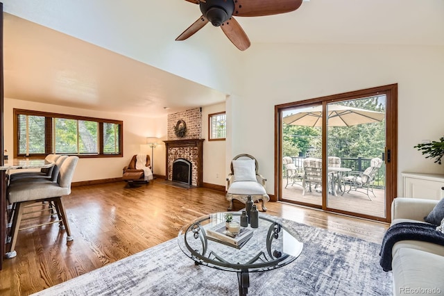 5475 W Ottawa Ave, Littleton, CO 80128 - living area featuring lofted ceiling, wood finished floors, a brick fireplace, a ceiling fan, and baseboards