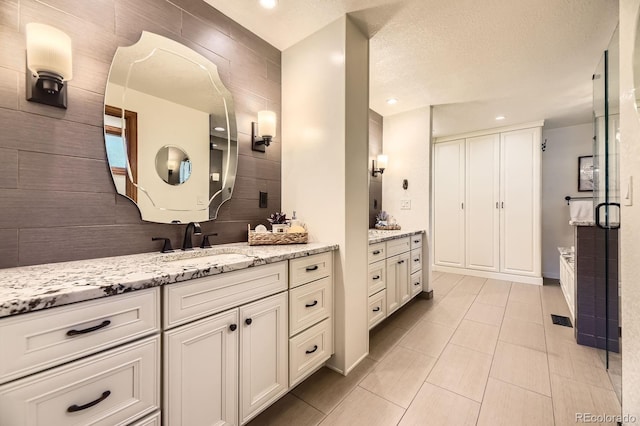 5475 W Ottawa Ave, Littleton, CO 80128 - bathroom with two vanities, recessed lighting, tile patterned floors, and a shower with shower door