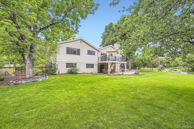 5475 W Ottawa Ave, Littleton, CO 80128 - back of house with a wooden deck, a patio, and brick siding