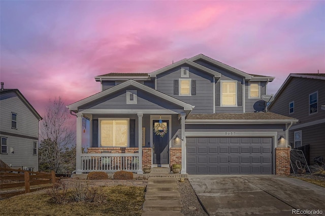 traditional home with a porch, an attached garage, brick siding, fence, and driveway