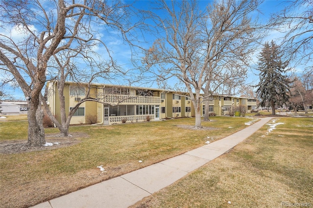 view of front of home featuring a balcony, a residential view, and a front yard