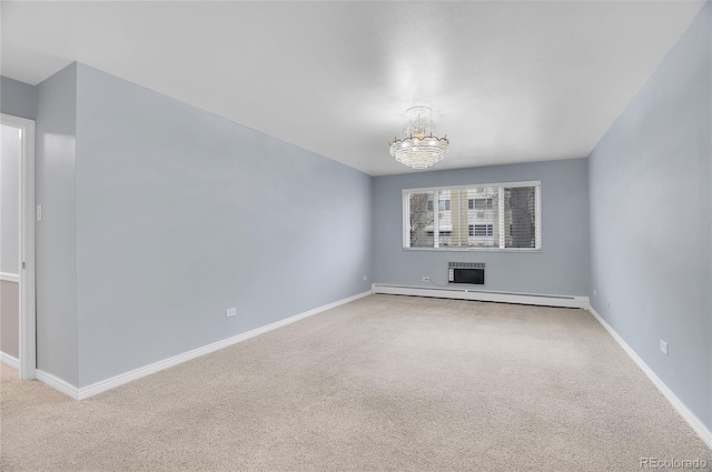 carpeted empty room featuring a baseboard radiator, baseboards, and an inviting chandelier