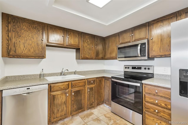 14001 E Marina Dr Unit 606, Aurora, CO 80014 - kitchen with appliances with stainless steel finishes, a sink, light tile patterned flooring, light countertops, and a raised ceiling