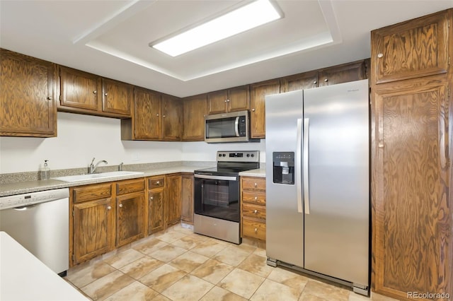 14001 E Marina Dr Unit 606, Aurora, CO 80014 - kitchen with appliances with stainless steel finishes, a sink, a raised ceiling, and light countertops