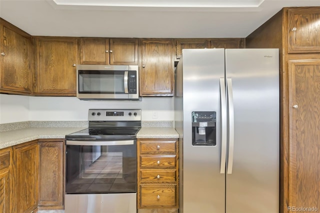 14001 E Marina Dr Unit 606, Aurora, CO 80014 - kitchen featuring appliances with stainless steel finishes, light countertops, and brown cabinetry