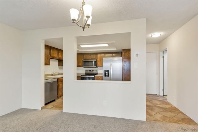 14001 E Marina Dr Unit 606, Aurora, CO 80014 - kitchen with appliances with stainless steel finishes, a chandelier, a sink, light colored carpet, and light countertops