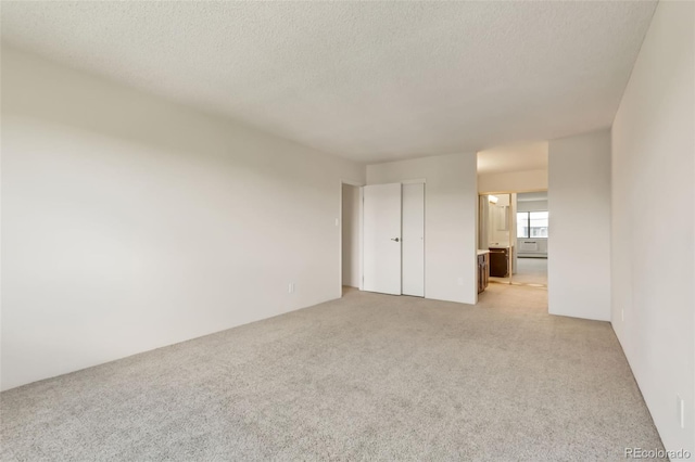 14001 E Marina Dr Unit 606, Aurora, CO 80014 - unfurnished bedroom featuring light colored carpet, ensuite bath, and a textured ceiling