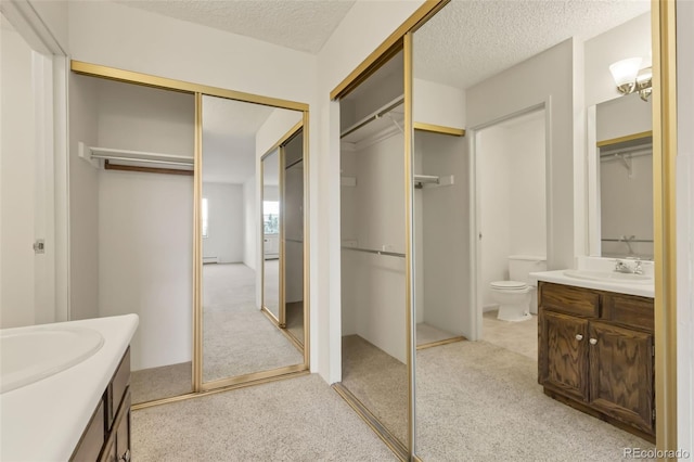 14001 E Marina Dr Unit 606, Aurora, CO 80014 - full bathroom featuring vanity, a textured ceiling, toilet, a spacious closet, and baseboard heating