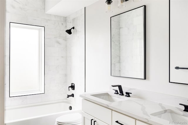 full bathroom featuring vanity, tiled shower / bath combo, and toilet