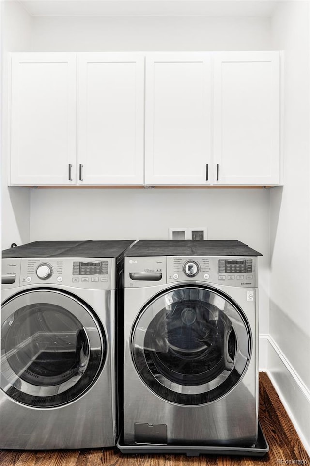 laundry room featuring dark wood-type flooring, cabinets, and independent washer and dryer