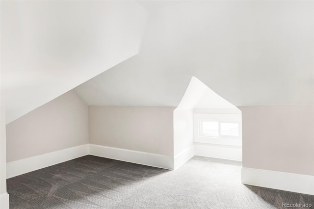 bonus room featuring dark colored carpet and lofted ceiling