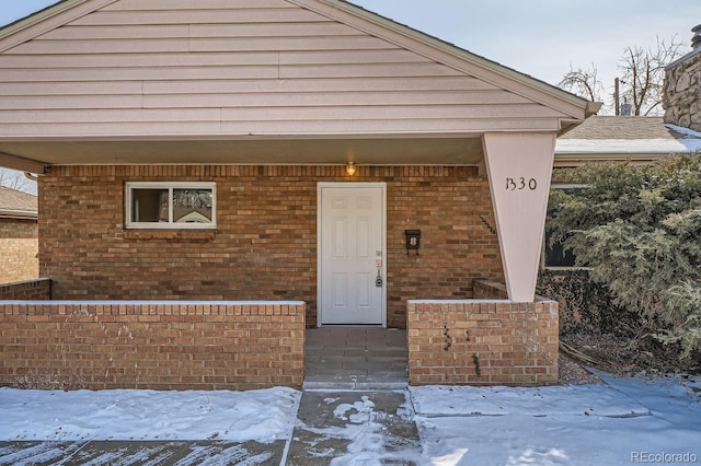 exterior space featuring brick siding and a shingled roof