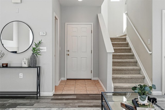 entryway featuring stairs, baseboards, and wood finished floors