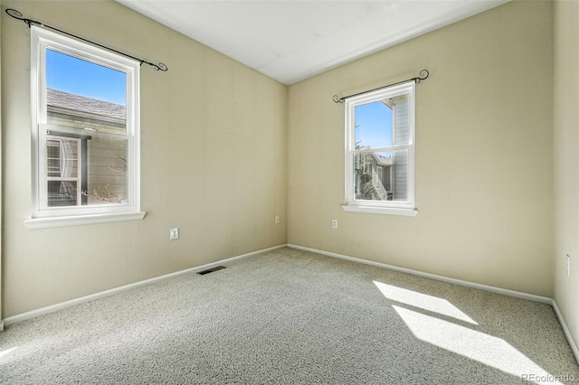 carpeted spare room with baseboards and visible vents