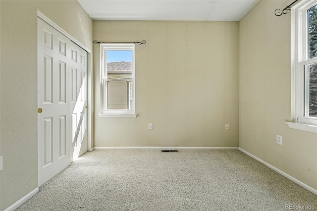 unfurnished bedroom featuring carpet flooring, a closet, visible vents, and baseboards