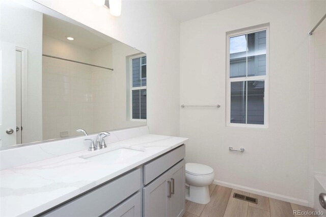 bathroom with vanity, toilet, and hardwood / wood-style flooring